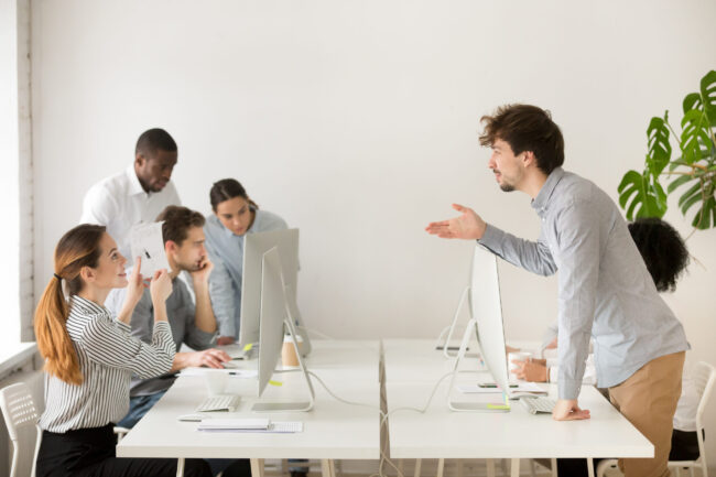 Smiling woman explaining corporate paperwork to new hire in offi